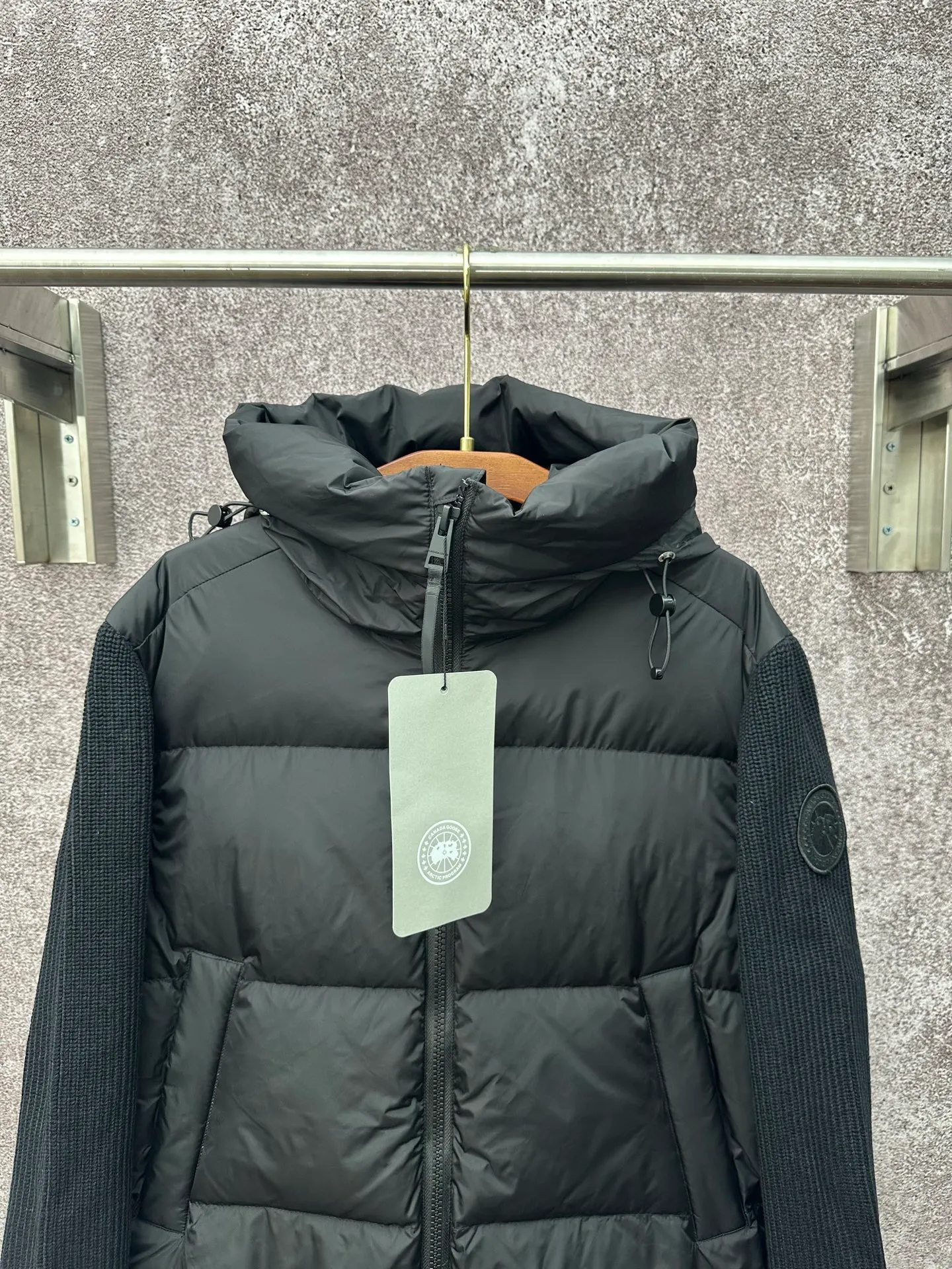 P930 Canada Goose Armband Hooded Down Jacket Fabric selection: The use of high-quality protective nylon fabric not only enhances the wear resistance of the surface, but also takes into account wind resistance, ensuring excellent performance in various harsh weather conditions.  90 national standard high-quality white duck down: selected high-loft down, weighing 170g, light and warm, with excellent temperature locking performance and good resilience.  Three-dimensional quilting process: Precision thread reinforcement to prevent velvet drilling and ensure that the fluffy and resilient elasticity lasts as new.  7-needle medium-thick knitted structure: Use thicker yarns to knit woolen fabrics with obvious thickness and weight. The texture is clearly visible and has a rough, retro texture. It has a good skeleton feel, is relatively stiff, and can maintain the silhouette of clothing for a long time. It also provides more layers of still air to lock in heat.  There is a brand exclusive LOGO on the woolen sleeve arms. It is dark and not obvious in the photo.  Accessories: One-to-one customized logo, one-to-one customized zipper pendant, one-to-one customized snap button SIZE: S M L XL